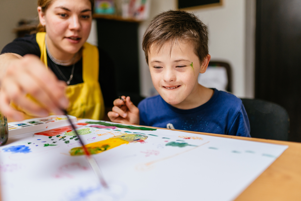 An SET helping a child paint